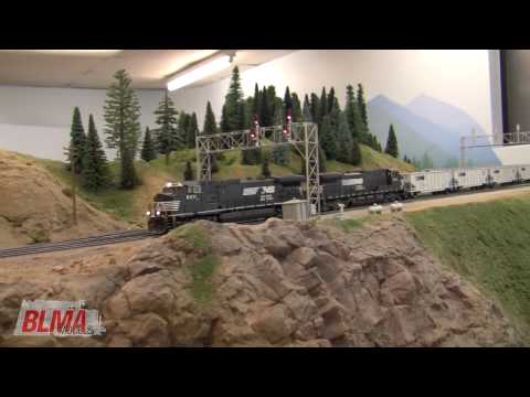 Visit Tim Dickinson's HO Scale model train layout for an unusual sight - Norfolk Southern locomotives and TopGon coal cars traversing the line between Spokane and Seattle, Washington. In due time, we'll cover awesome Burlington Northern action from the mid-70's on Tim's layout. Featured in this video are Paul Federiconi and his completely custom, Norfolk Southern Dash9's. Complete with ALL of the detail you could imagine (including some new Details West NS and Dash9 products), Paul even went as far as adding sound to the models with the correct, custom programmed, K5 horn and air compressor - not currently available on the market. Sound decoder by Loksound. Paul painted the models and used decals from ShellScale Decals (www.shellscale.com) Visit: www.detailswest.com Paul's Dash9's pull 36 BLMA Models HO Scale TopGon Coal Cars in smooth, modern fashion. Running empty, the train makes good speed through the flat lands, powers it's way up the grade, and glides down the hill in dynamics for a meet with an intermodal train holding the main. Please visit our website for additional information on the Norfolk Southern TopGon's and other products: www.blmamodels.com