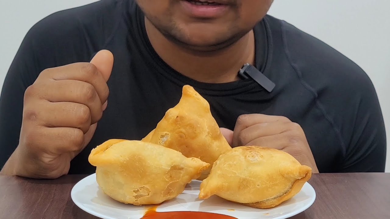 EATING SAMOSA WITH TOMATO SAUCE