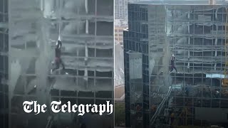 video: Watch: Construction worker left dangling from crane by one hand