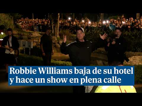 Robbie Williams leaves his hotel and performs a show in the middle of the street after his concer...