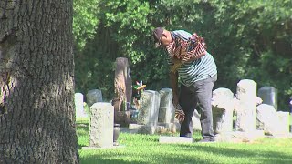 American Legion Dorie E. Miller Post 817 place flags on graves at Live Oak Cemetery in Port Arthur