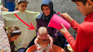 Bathing in the open air; Akram bathes her children with love