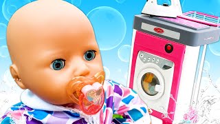 Baby doll's clothes are dirty. Toy washing machine for dolls. Pretend to play with baby dolls.