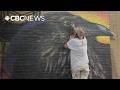 Mural artist Archer spraying character into back alleys and on barn doors across B.C. this summer