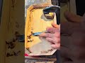 The process of carving the inner surface of a wooden tray using a sharp chisel tool in carpentry