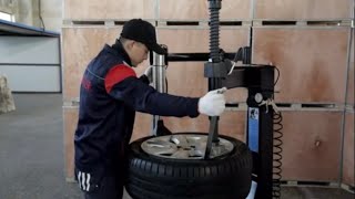 Using a tire machine assist arm