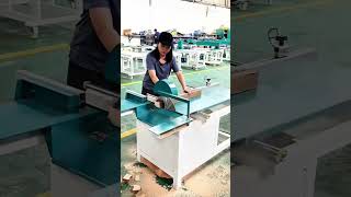 Inspecting table saw machine in woodworking factory
