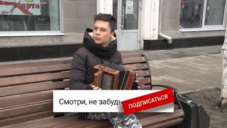 Талантливый музыкант играет на гармони с колокольчиками на улице