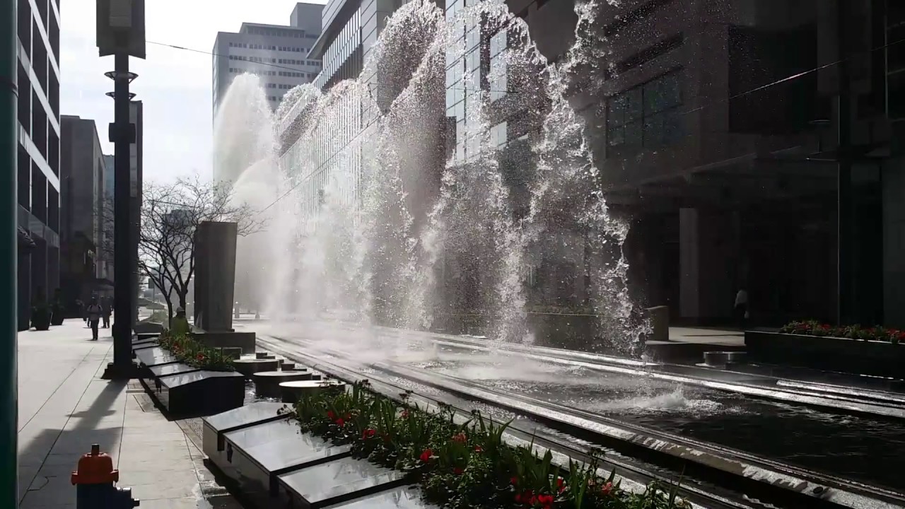 Metro train running through a water feature on Main Street in Downtown Houston.