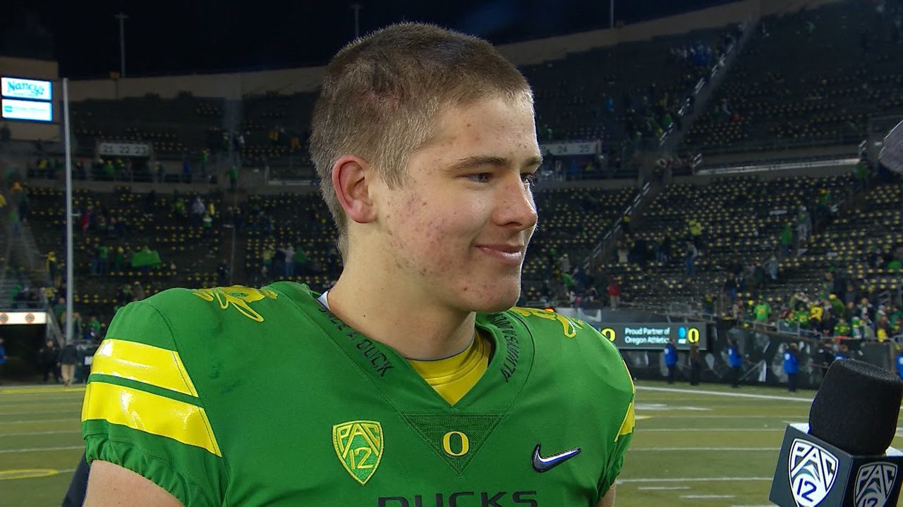 Pac-12 Networks' Lewis Johnson talks to Oregon quarterback Justin Herb...