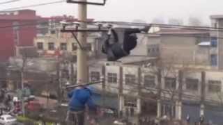 Drunk man dangles upside down on power cable in China