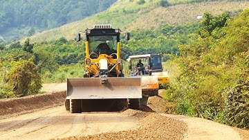 Awesome heavy construction equipment grading and leveling a gravel road with motor grader is at work