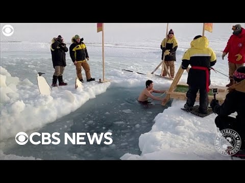 Antarctic expeditioners plunge into icy water for mid-winter swim.