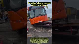 Slowly guide or winch the bus off the trailer bed.