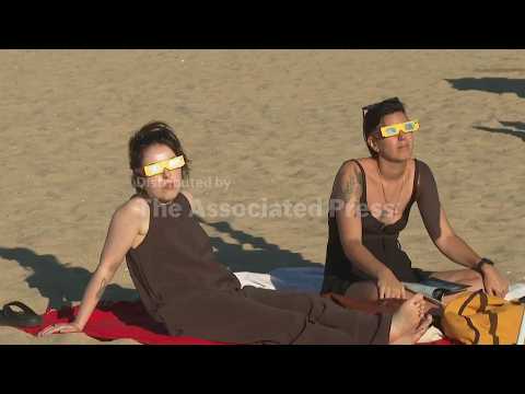 Portuguese enjoy rare solar eclipse at beach south of Lisbon