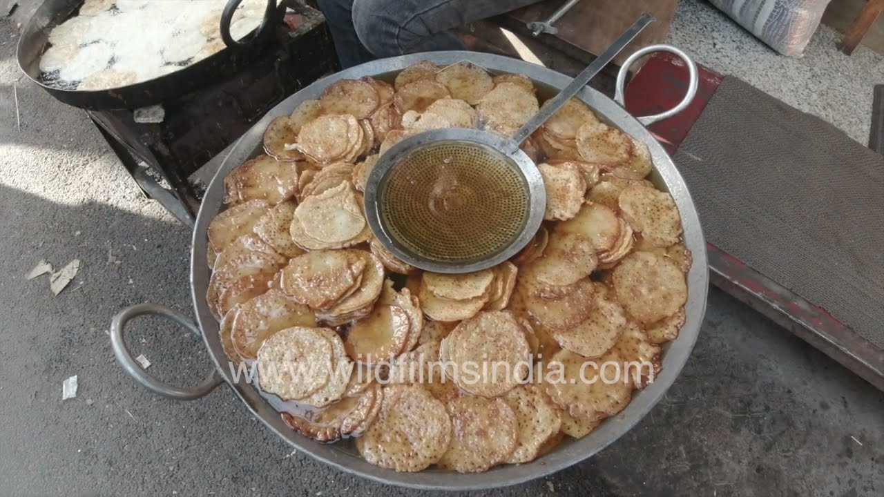 A street vendor prepares fresh Malpua at the vibrant Pushkar Mela in Pushkar