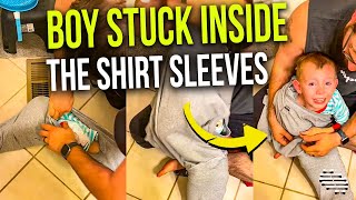 Dad Helping His Boy Who Has Gotten Himself Stuck Inside the Sleeves of Mom’s Shirt