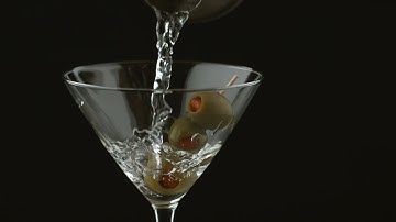LIQUID BEING POURED OVER OLIVES IN A MARTINI GLASS EXTREME SLOW MOTION 4K