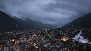 Aerial panorama in time lapse revealing Chamonix Mont Blanc nestled among alpine peaks, glowing