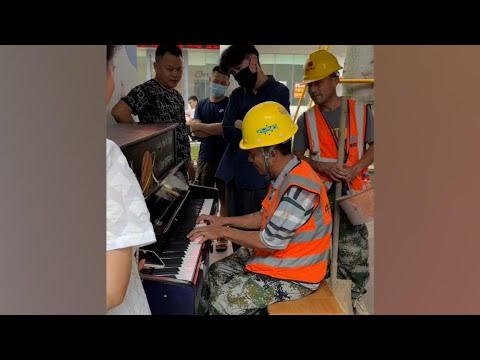 六旬大叔穿工服戴安全帽在大街上弹奏钢琴，引不少路人驻足