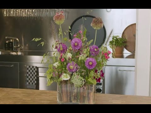 Vaas met zonnebloemstelen en bloemen