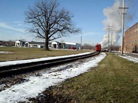 One of Owosso, Michigan's many great assets is the Steam Railroading Institute, which includes a museum and other facilities. The institute's 3.5 acre grounds also hold a roundhouse, the 800000 pound Pere Marquette 1225 steam locomotive and tender, the 82000 pound Flagg Coal Company steam switch engine, the 136000 pound Mississippian steam locomotive (under restoration), plus many train cars and other rolling stock from railroads in the United States and Canada. The Great Lakes Central Railroad is headquartered in Owosso, Michigan, as well. In this video the Pere Marquette 1225 is heading west as it crosses South Shiawassee Street in Owosso before it eventually heads north on a roundtrip to Chesaning, Michigan. A couple minutes later, a lone Great Lakes Central Railroad GMTX GATX diesel makes the same crossing on the same track.