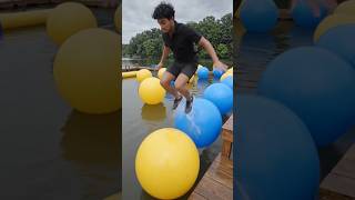 High-level focus on her balance and movement across the water obstacles.
