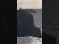 Winds blowing waterdrops back up in the air as they flow off the cliff edge. Cliffs of Moher.