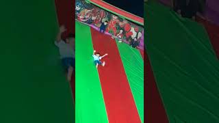 Boy Flips While Sliding on Big Bouncy Castle