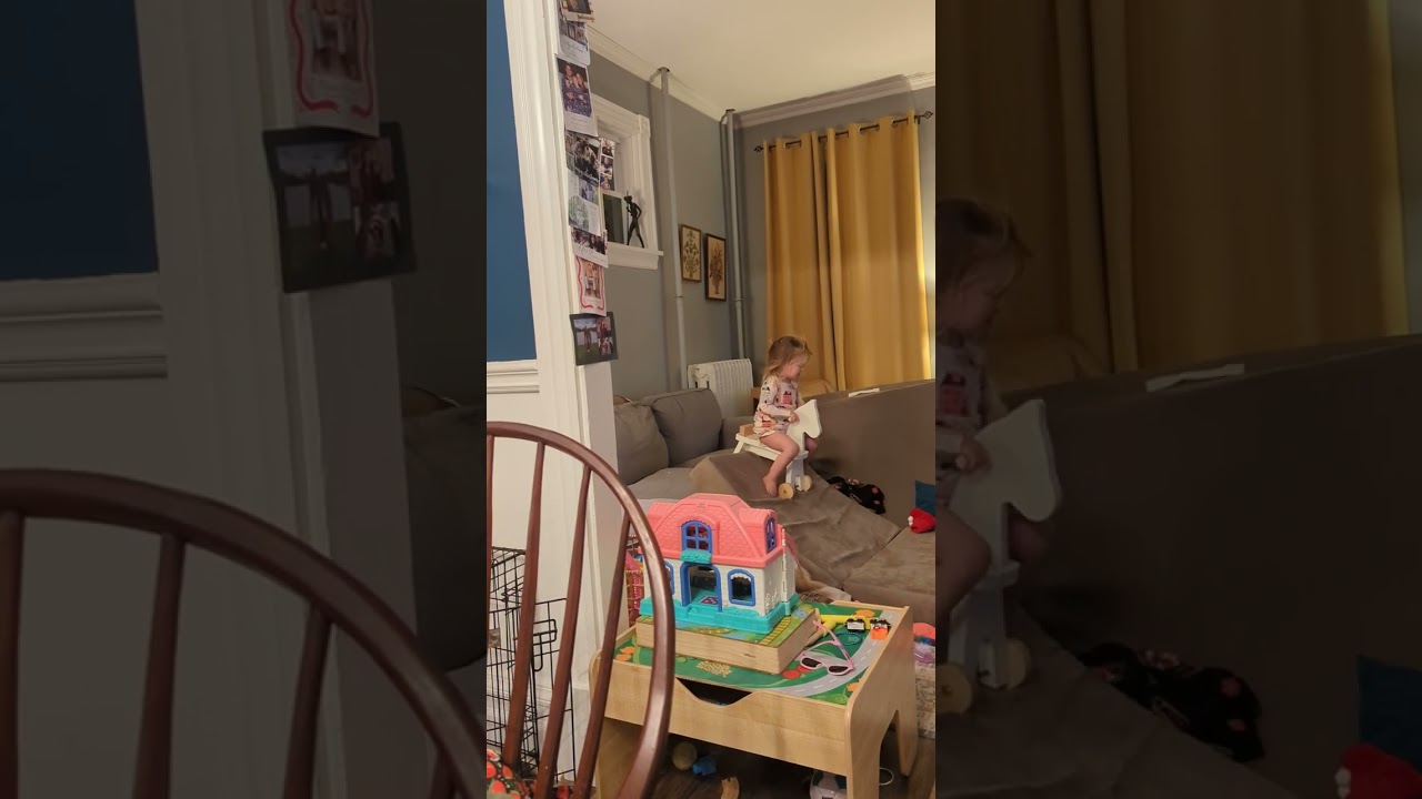 Little girl rides toy horse walker down couch cushion ramp and faceplants on floor in living room