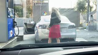Blonde woman tries to fill up a Tesla Model S with gas