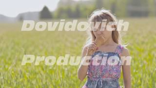 Beautiful blond little girl eats ice-cream in the summer next to the wheat field. Warm sunny day