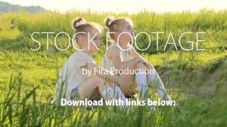 Two little girls sitting on grass talking have fun