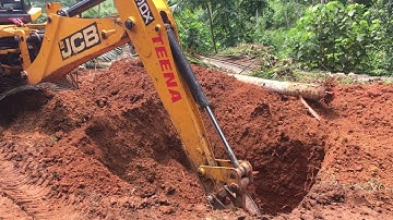 jcb 3dx digging soil and pulling roots of tree out
