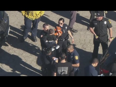 LAPD officers comfort child from Panorama City police scene