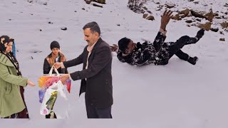 Humanity: A kind man helps a woman with two children in the mountains and snow.