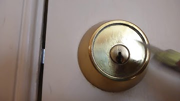 Remove the cover plate on the inside of a Medeco commercial lockset.