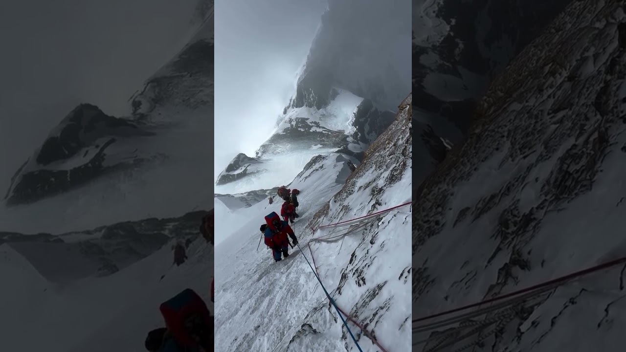Climbers on the rock slabs below the South Summit. Camp 4 at the South Col is visible below.