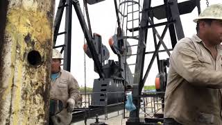 Workover rig running rods in the hole