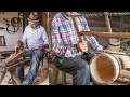 Old style cooper makes wooden barrel with hand tools