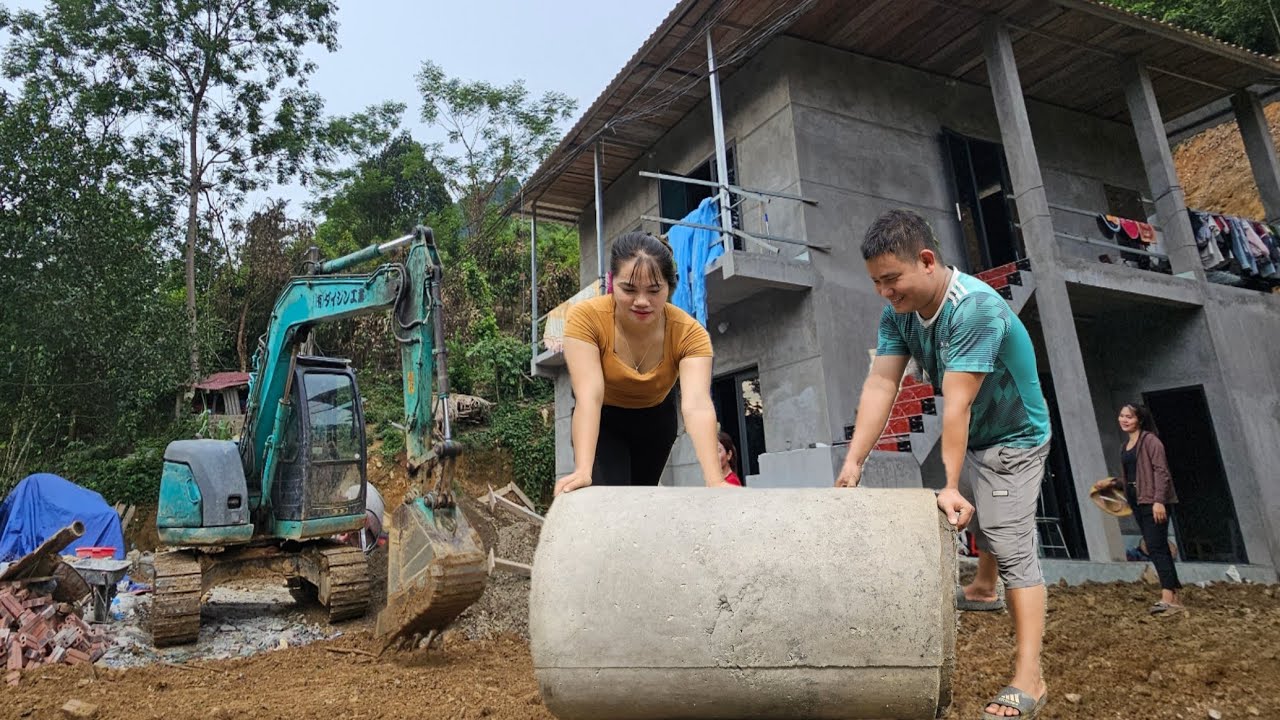 The excavator works in the largest newly built two-story house in the village 