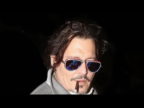 Johnny Depp sports a smart suit as he puffs on a cigarette in Mayfair ...