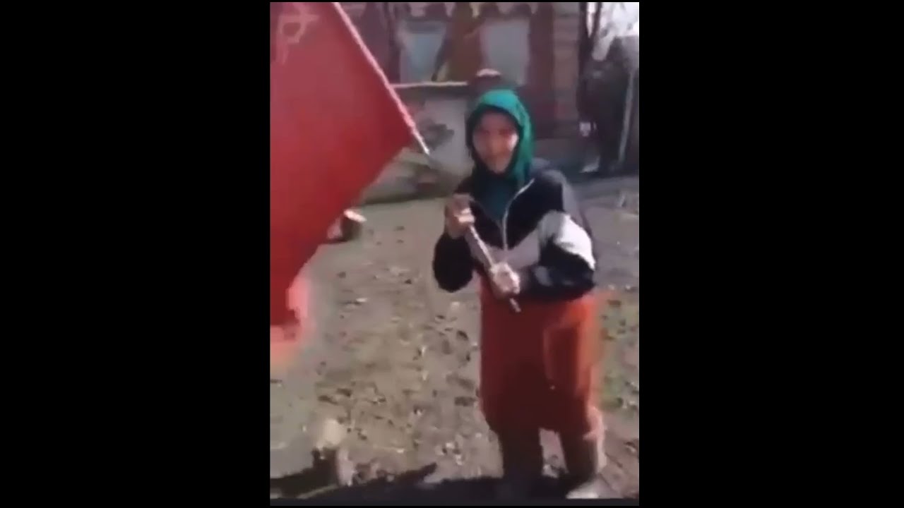 бабка с красным знаменем на украине. бабушка с красным флагом. растоптанный украинский флаг. старуха с советским флагом. бабушка с красным флажком.