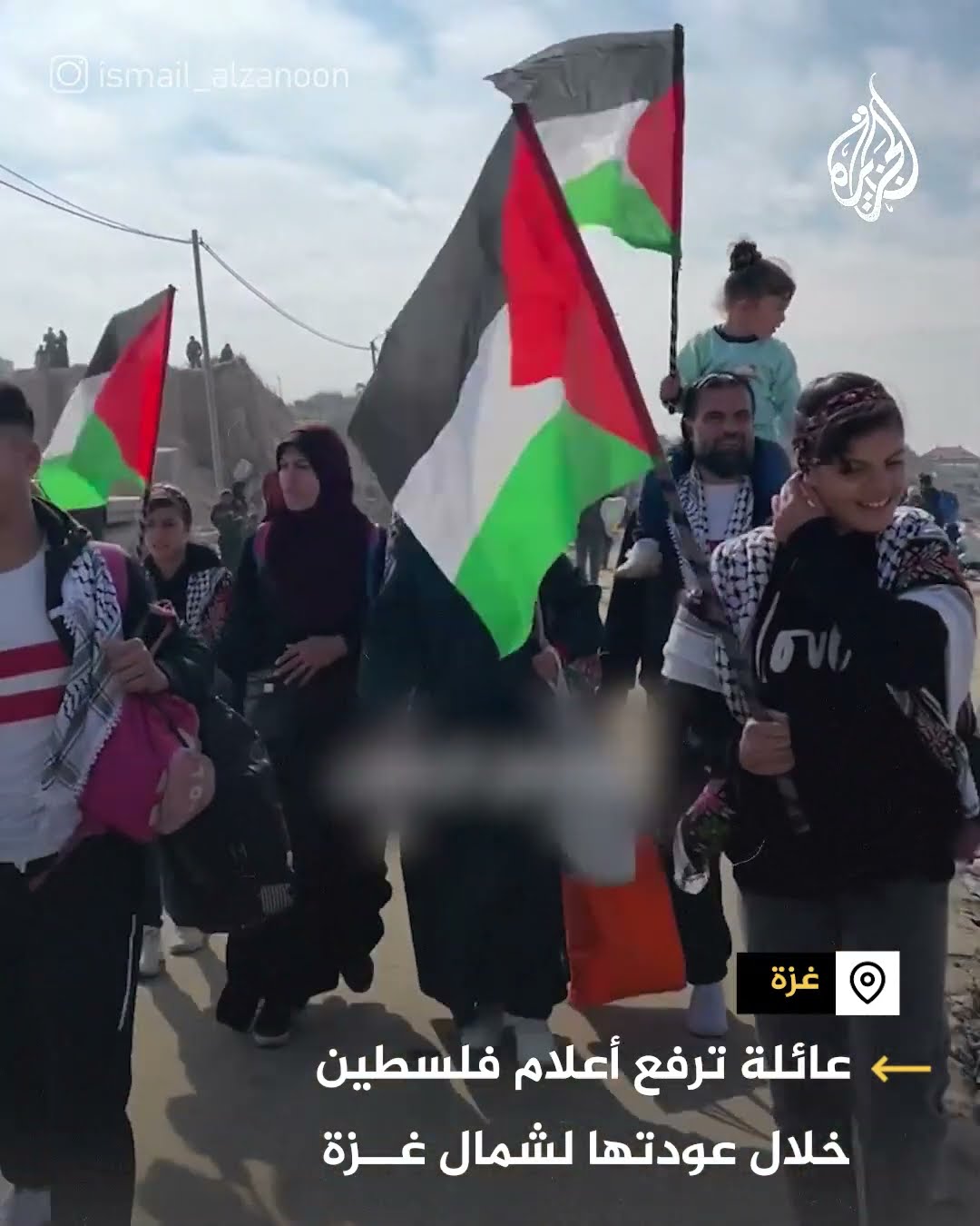 عائلة ترفع أعلام فلسطين خلال عودتها لشمال غزة