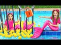 Sasha pretends play mermaid with water toys