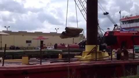 hardwood crane mats being hoisted onto a barge