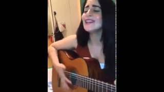 A Kurdish girl sings with a guitar