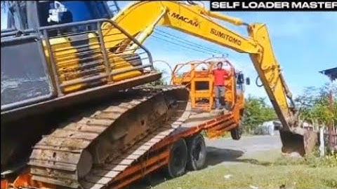 Here is the process of loading and unloading an excavator onto a self-loader truck