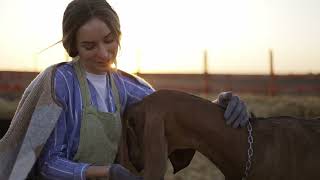 young woman interacts with adorable baby animal on local farm