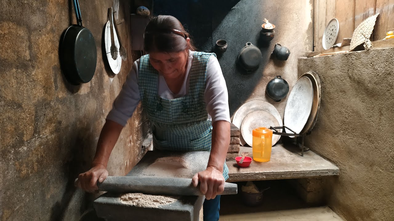 Preparo rico atole de pinole con granos de maíz tostados en comal y molido en metate